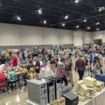 Large crowd at Vintage Computer Festival Midwest browsing exhibits, vendor tables, and retro computer setups.