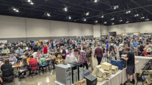 Large crowd at Vintage Computer Festival Midwest browsing exhibits, vendor tables, and retro computer setups.