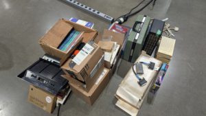 Boxes of vintage computer hardware, magazines, and accessories collected at Vintage Computer Festival Midwest.